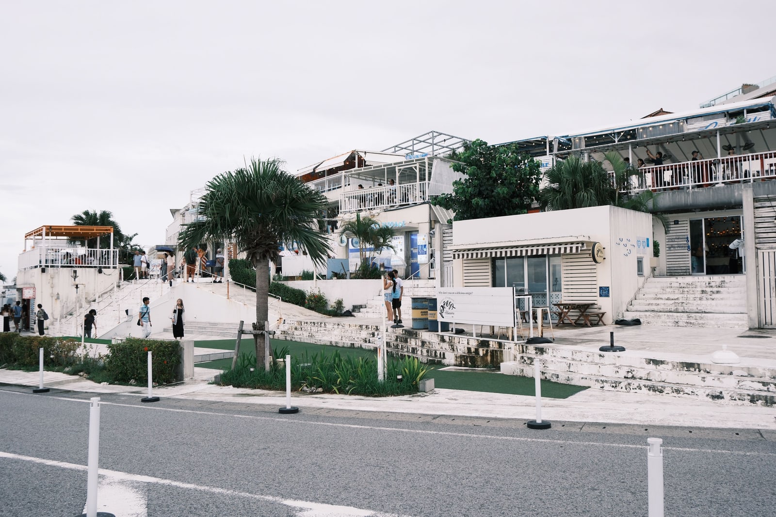 White buildings with open terraces and outdoor stairs under a grey sky