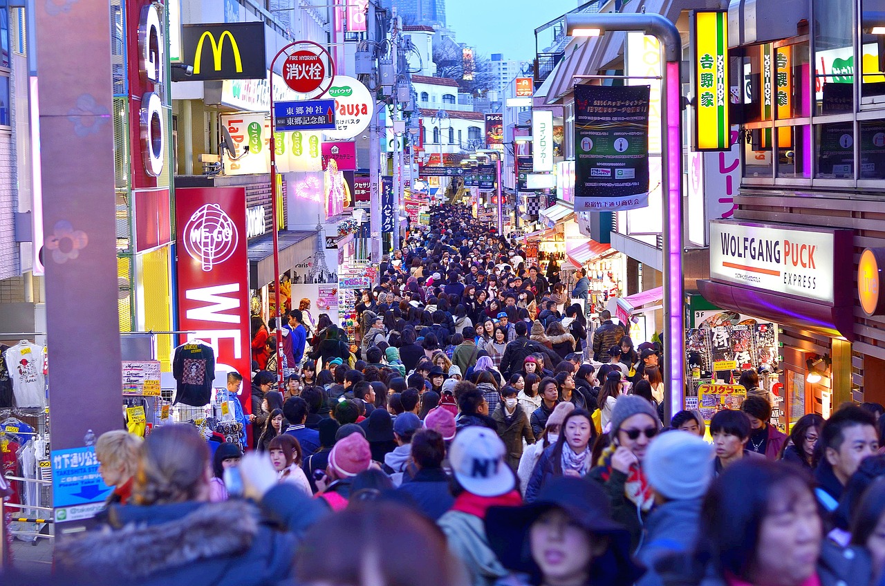 Takeshita Street at dusk, crowded with people in winter clothes between lit shop signs