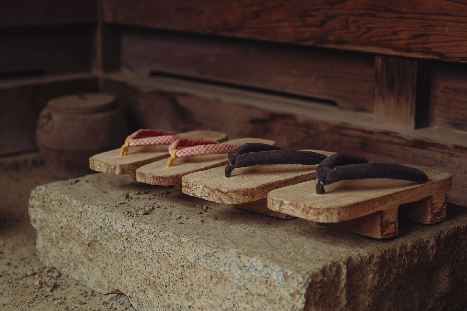 Two pairs of wooden geta on a stone step