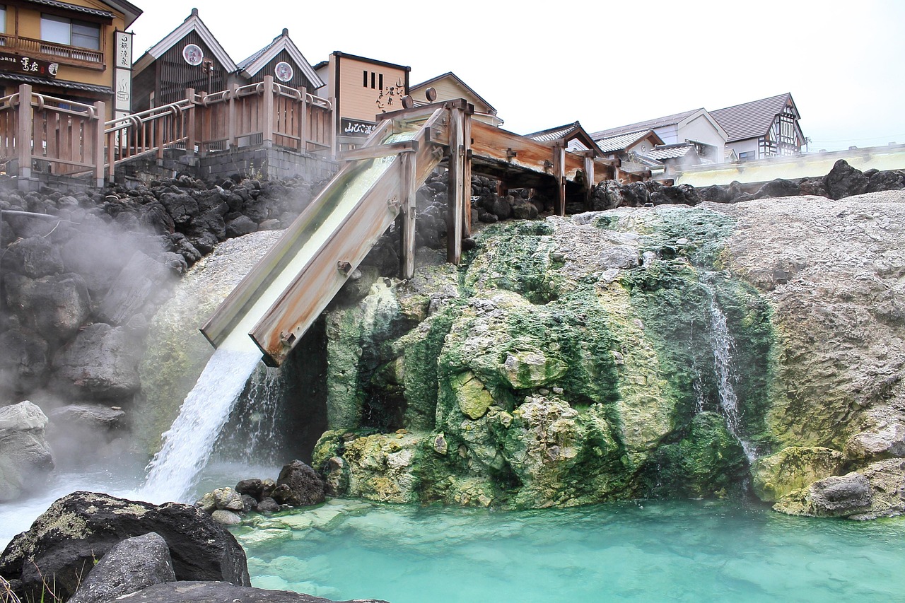 Hot water falling from the wooden channels of the Yubatake in Kusatsu into a turquoise pool