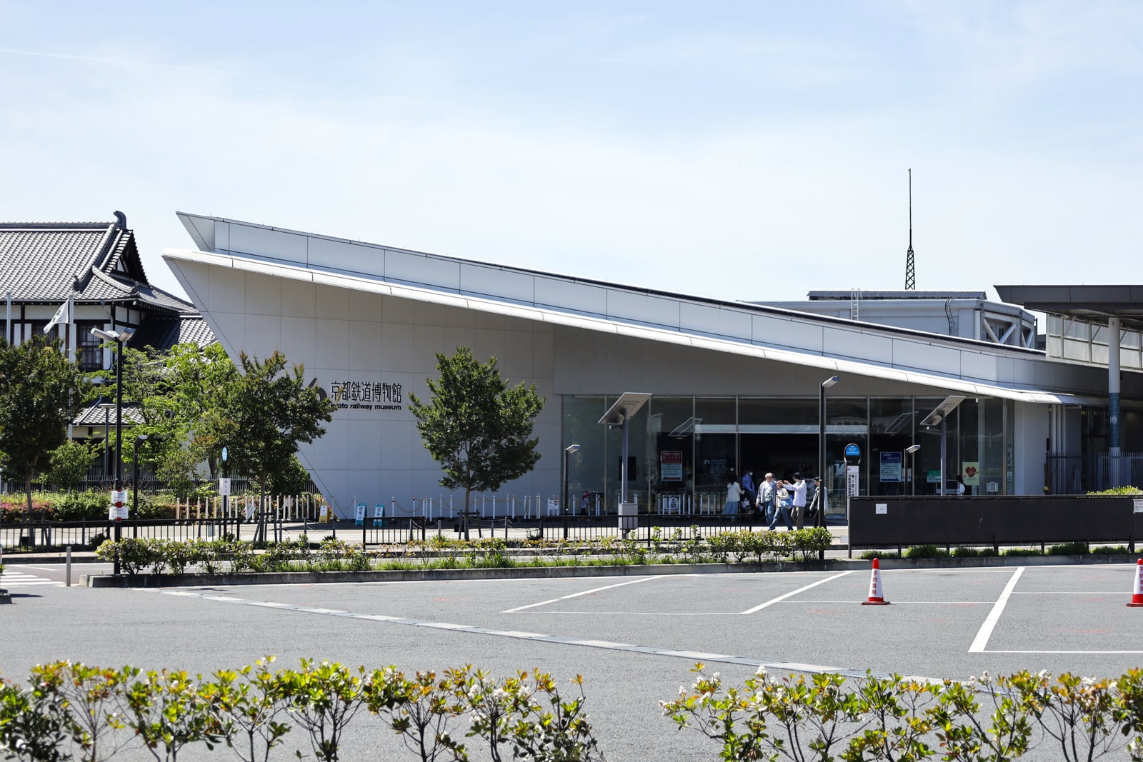 The white front of the Kyoto Railway Museum with its name on the wall, under a blue sky