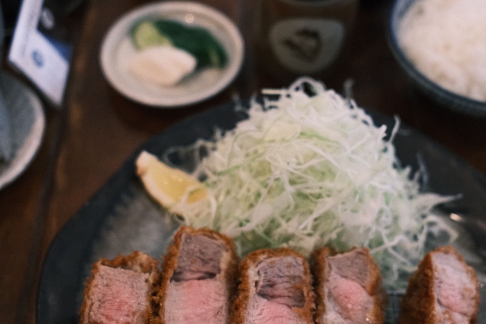 A breaded pork cutlet with shredded cabbage and rice.