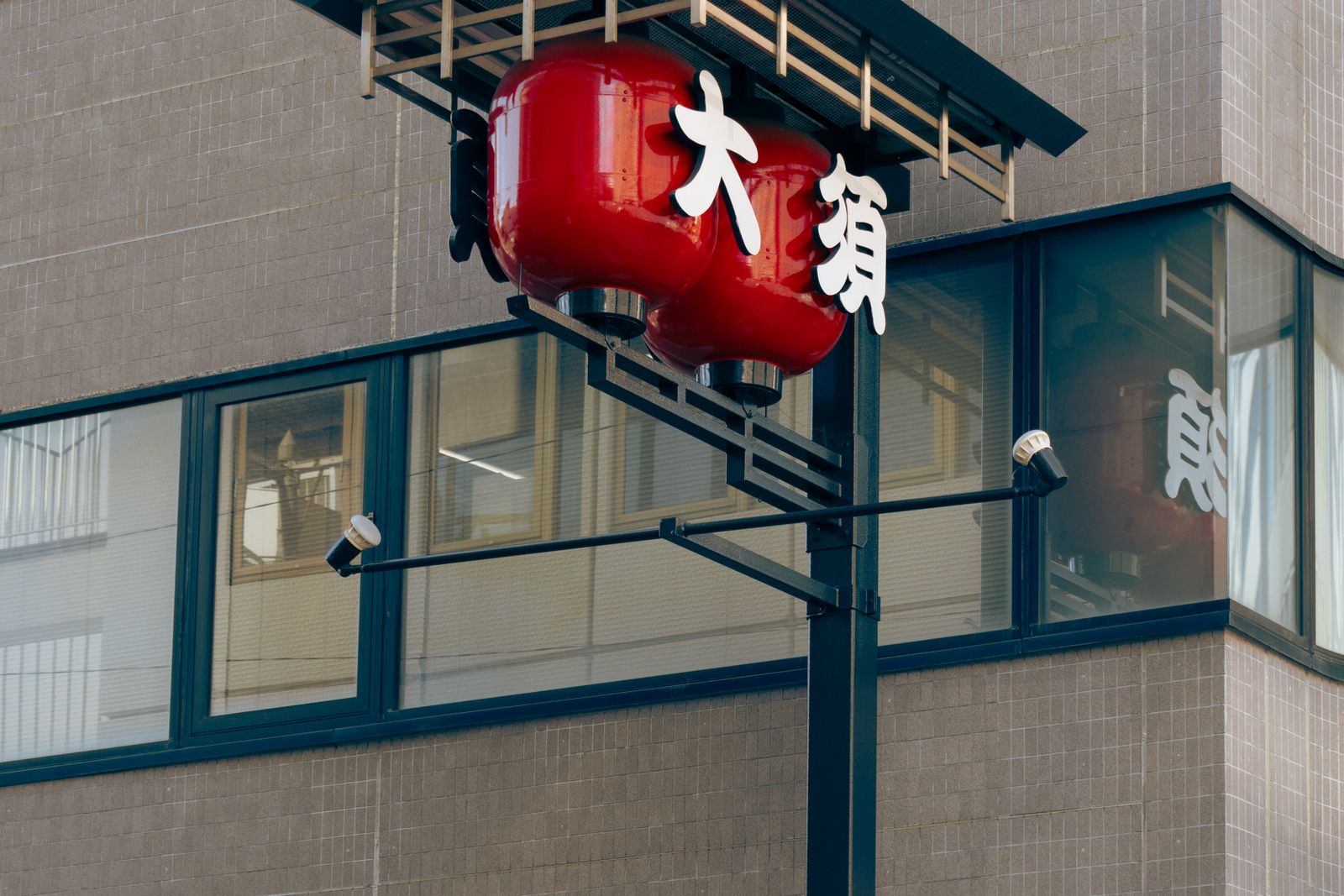 Red lanterns reading 大須 mounted on a street sign in Nagoya.