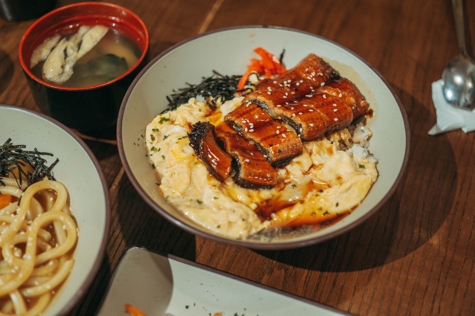 An eel and rice bowl served as a set with soup and side dishes.