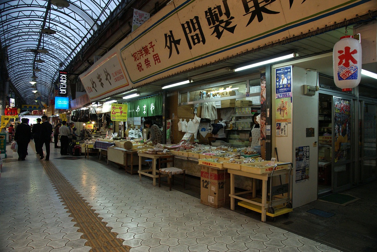 A covered market arcade in Okinawa with open-fronted stalls, a paper lantern and a tiled walkway