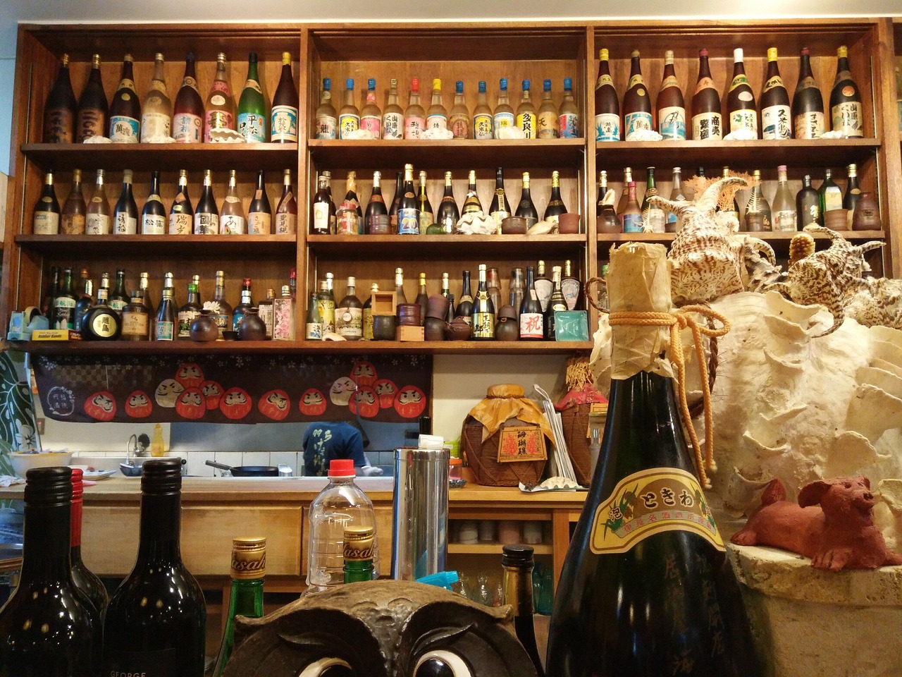 Shelves of awamori and other bottles behind a bar counter in Okinawa