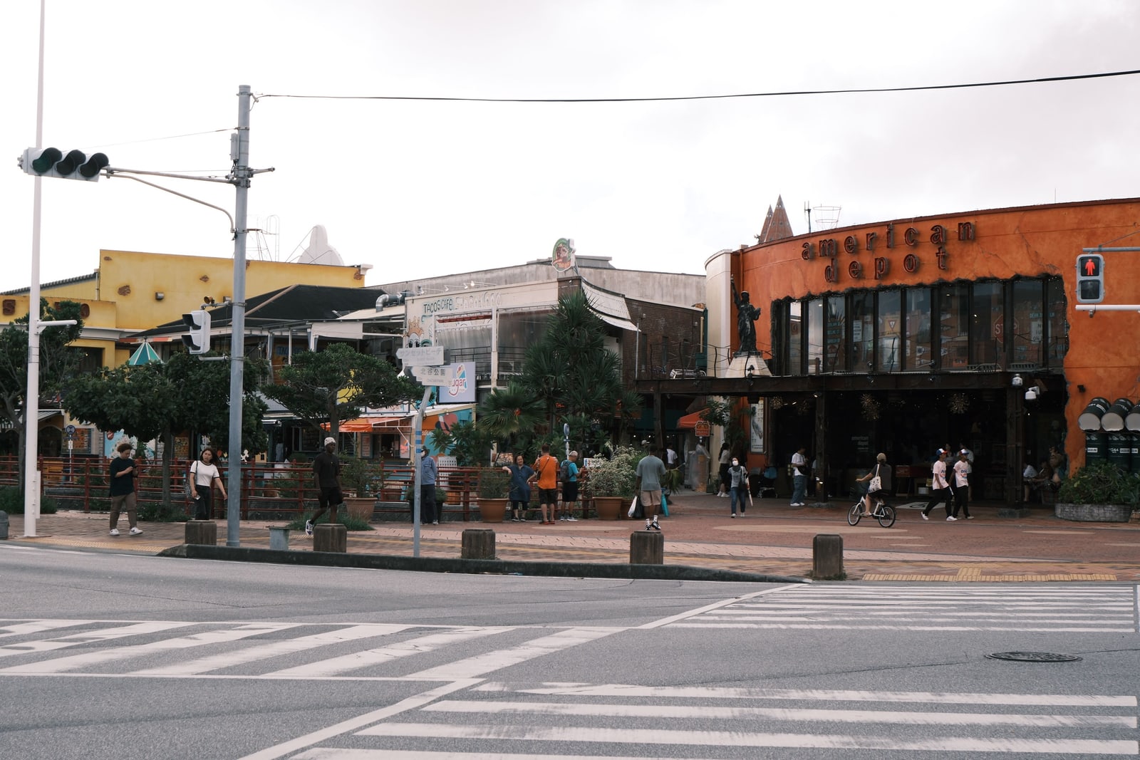 The American Depot store front in American Village, Chatan, with a small Statue of Liberty replica beside a road crossing