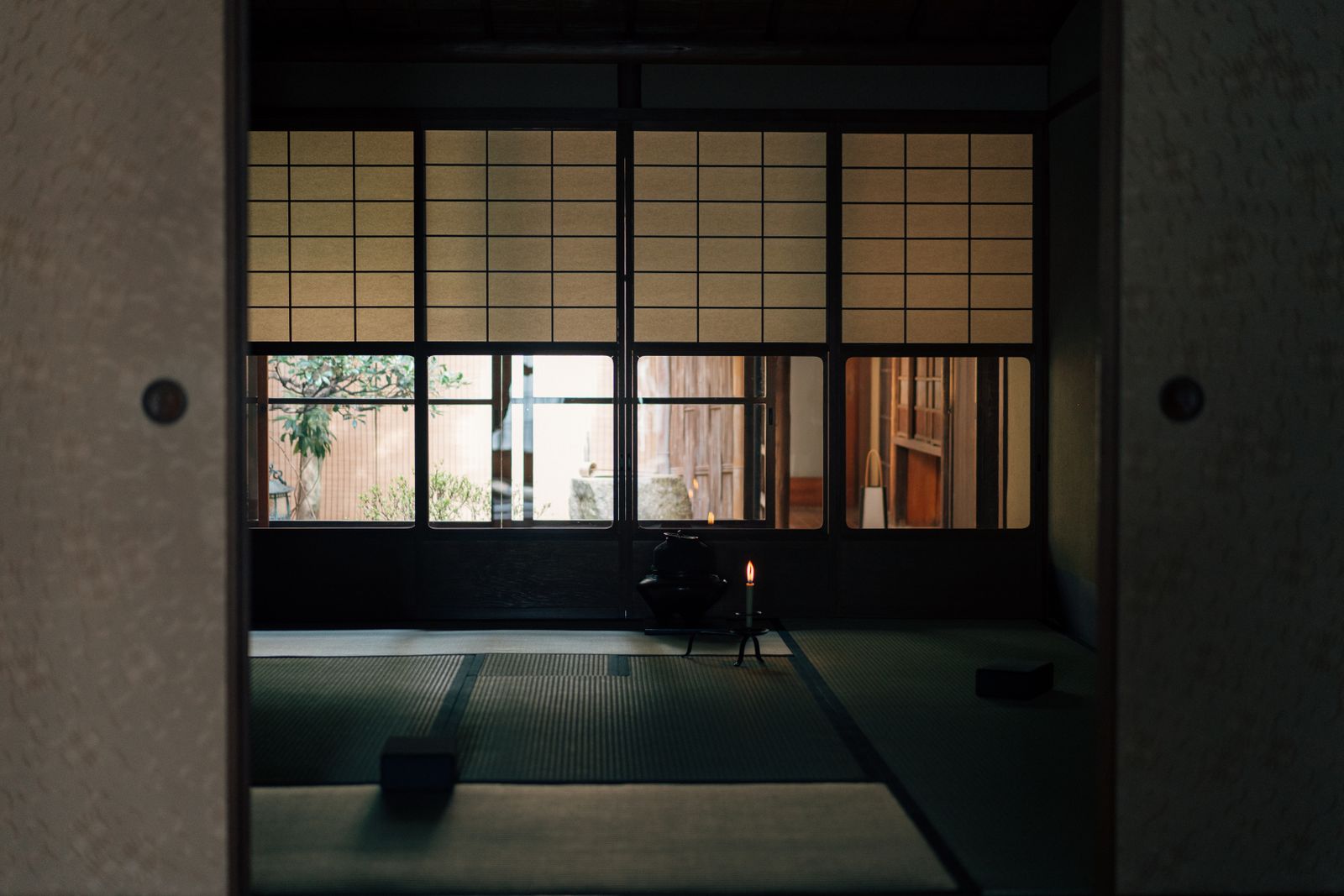 A quiet interior corridor with shoji screens filtering daylight.