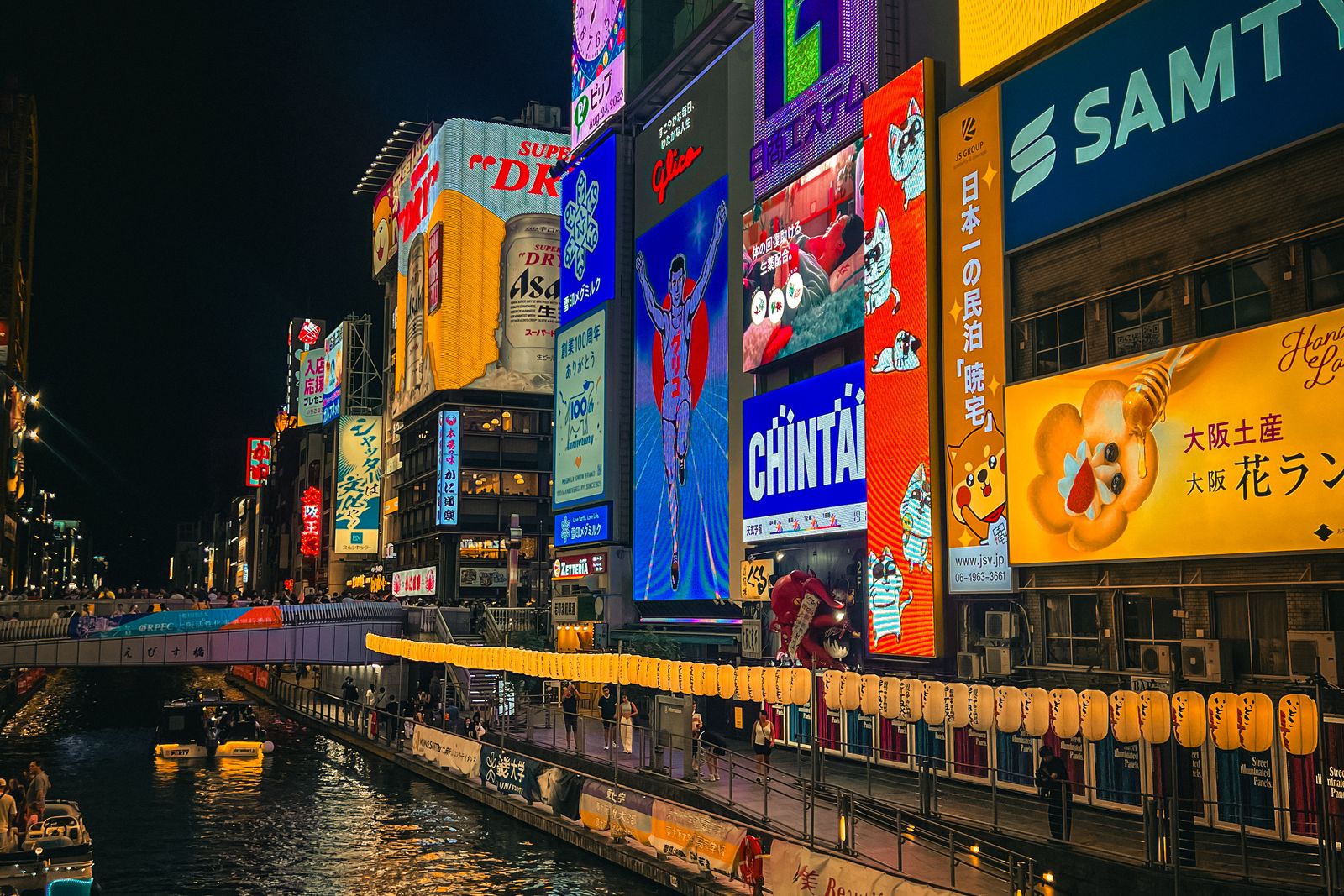 The Dotonbori canal at night, lit by the Glico running man and stacked neon signage.