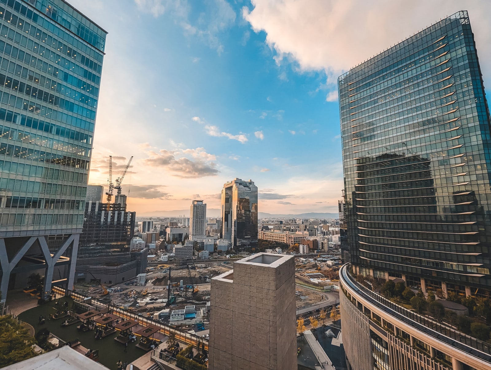 Osaka high-rises framing a low view of the city under an evening sky.