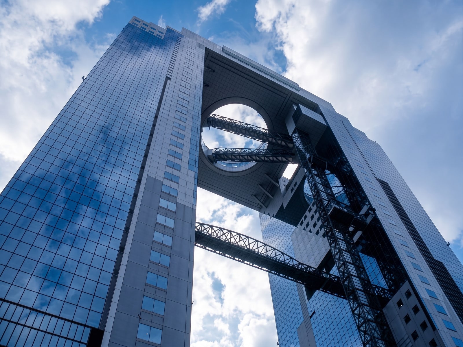 The Umeda Sky Building seen from below, two glass towers joined at the top by a ring-shaped observatory.
