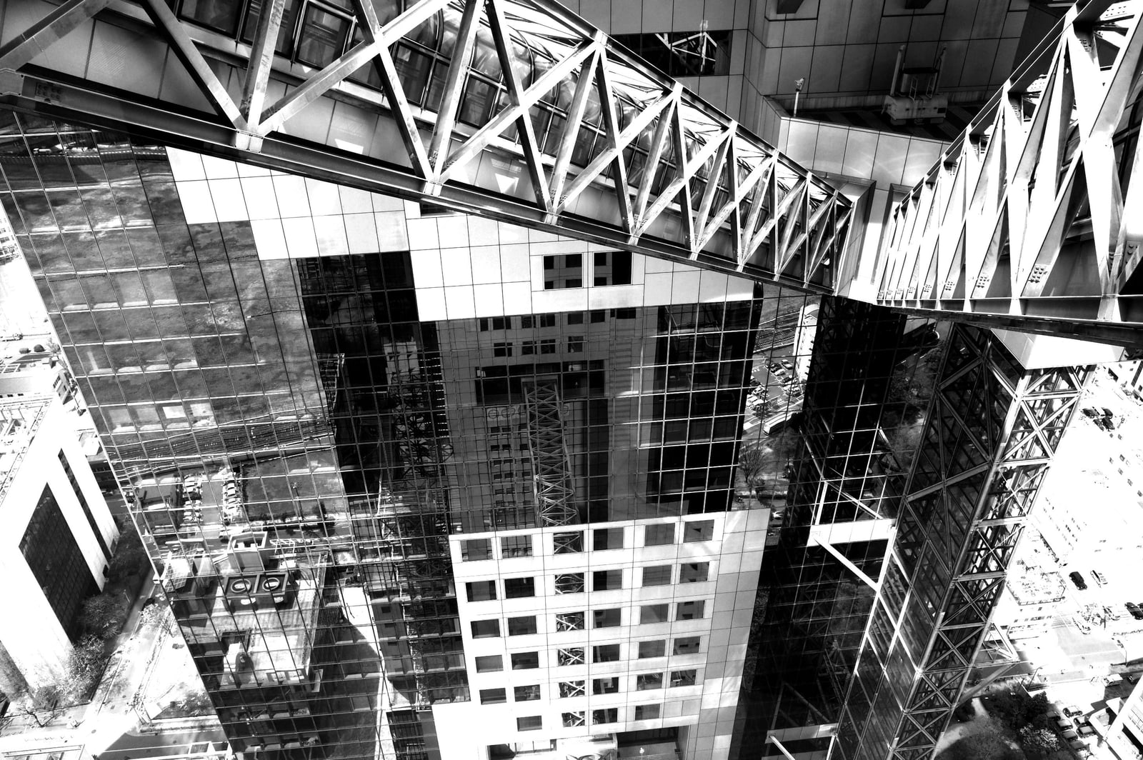 Black-and-white view of glass-sided bridge tubes running high between the two Umeda Sky towers.