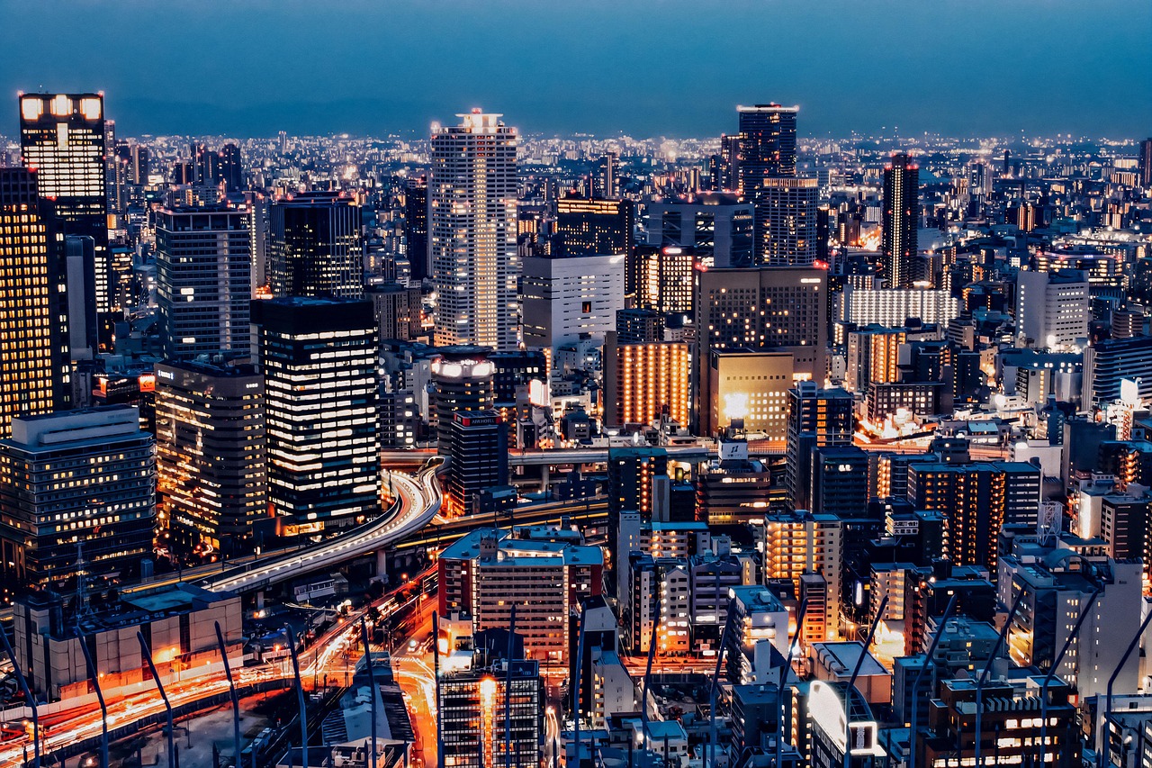 Umeda office towers and an elevated road lit up at night, seen from high above at blue hour.