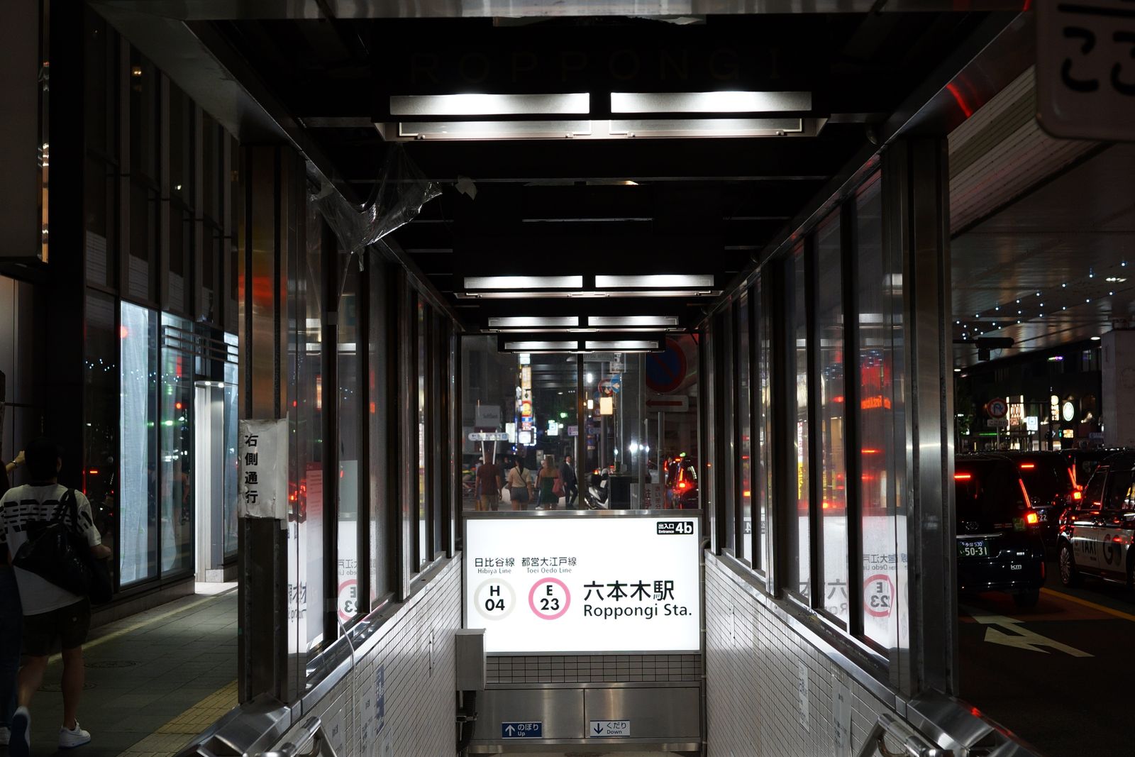 The Roppongi Station entrance 4b at night, signs for the Hibiya and Oedo lines over the stairs down
