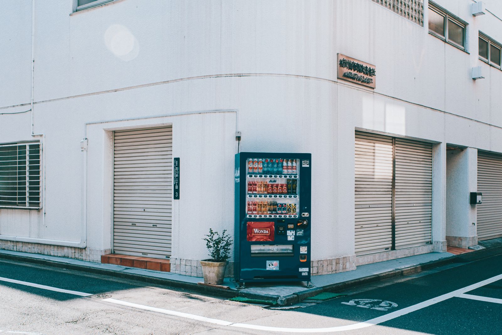 A quiet Asakusa corner with a single vending machine and a blue address plate.