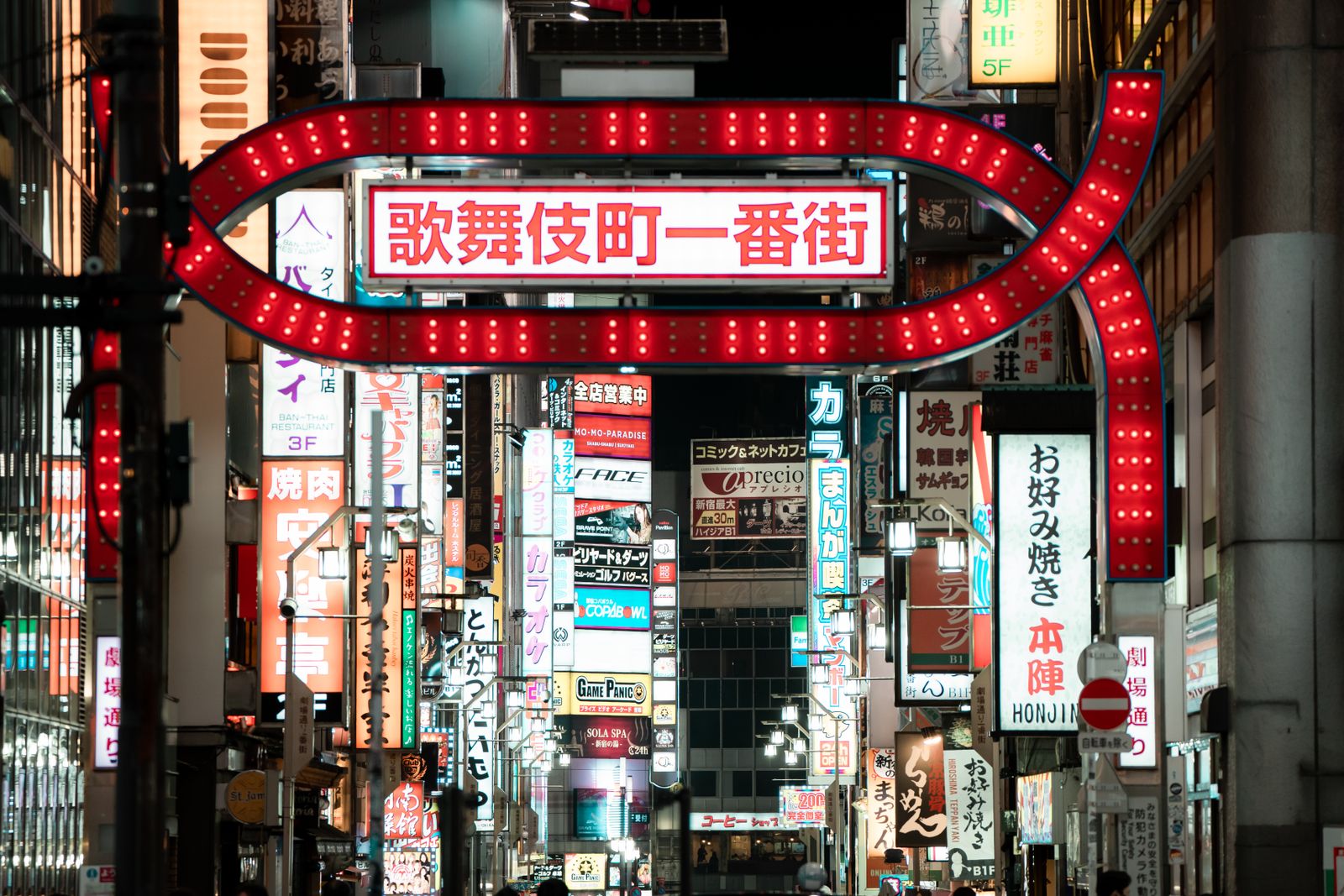 The illuminated 歌舞伎町一番街 arch at the entrance to the Kabukicho district at night.