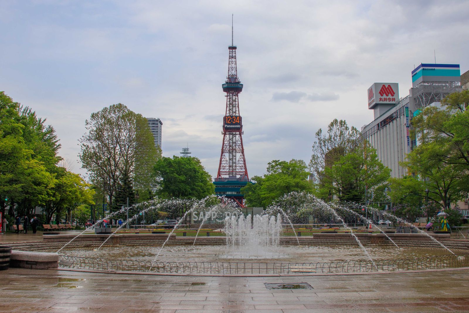 A fountain in Odori Park with the Sapporo TV Tower at the far end