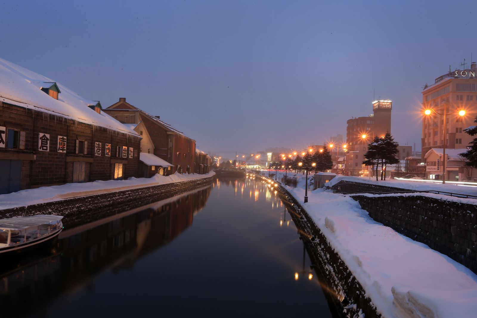 Otaru Canal at winter dusk, with snow on the stone warehouses