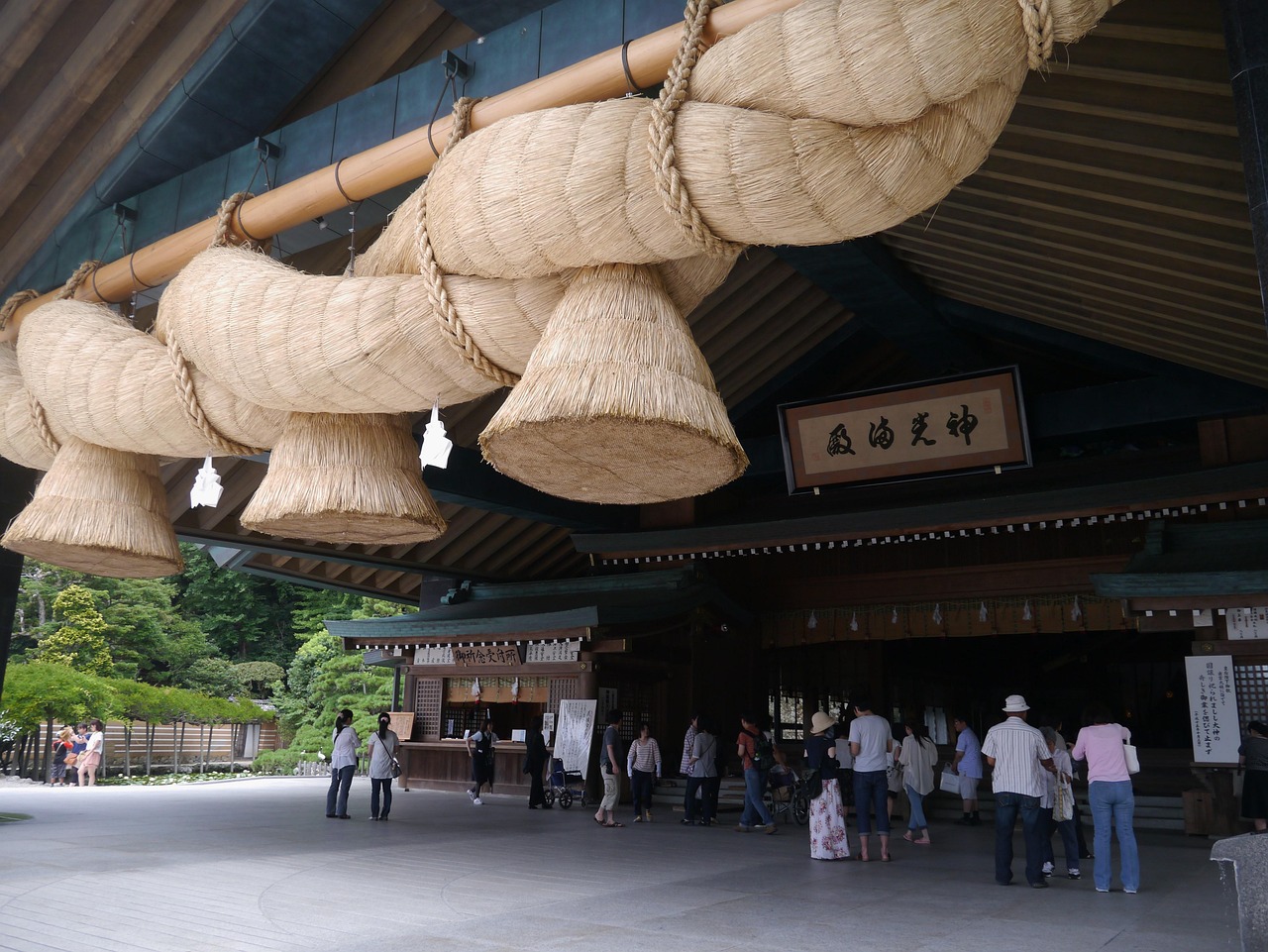 The giant straw shimenawa rope hanging at Izumo Taisha, visitors on the forecourt below