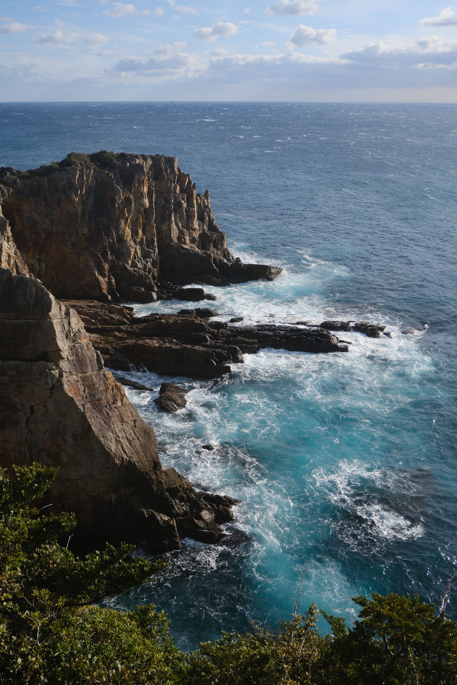 A rock headland and white surf on the open ocean
