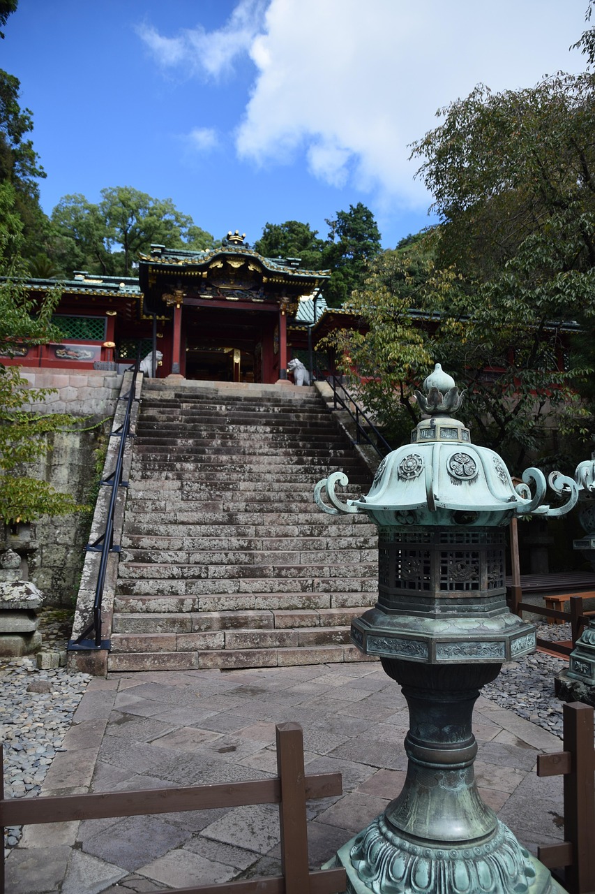 Stone steps leading up to a red and gold lacquered gate at Kunozan Toshogu