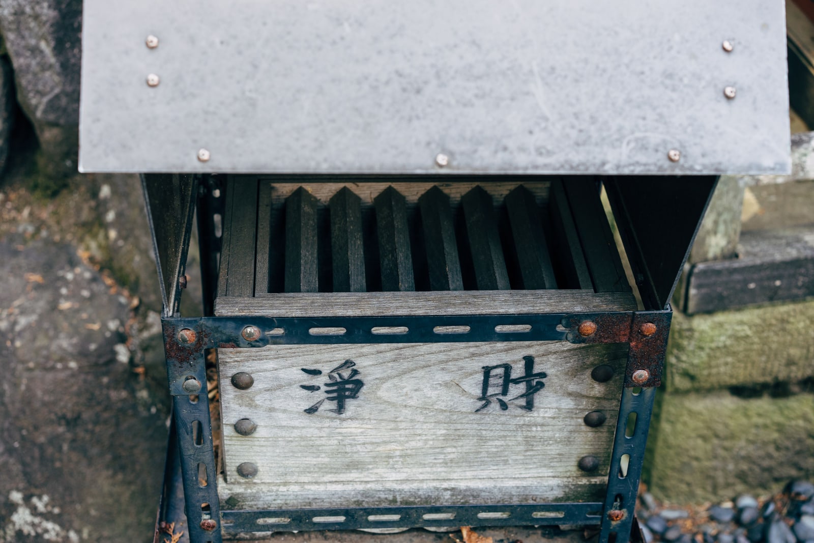 A wooden shrine offering box (saisen-bako) with a hand-painted donation panel.