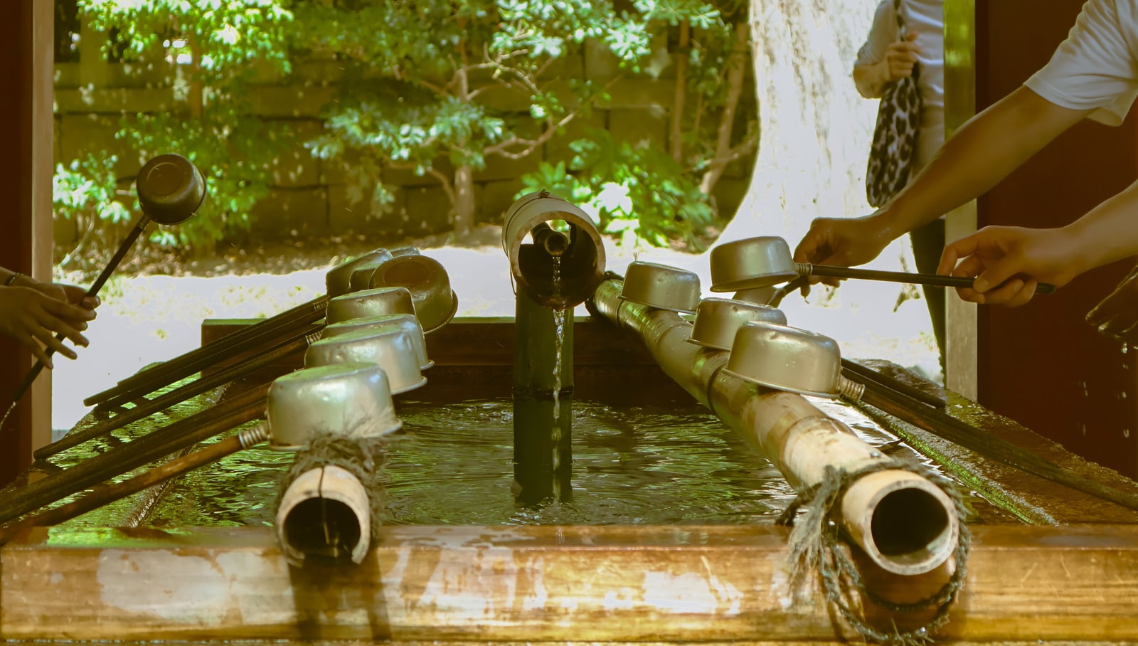 Wooden ladles resting on a shrine's temizuya purification basin.