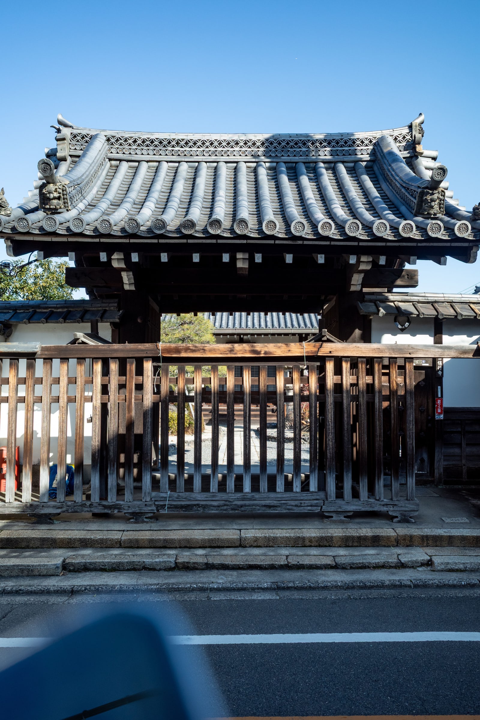 A wooden temple gate (sanmon) with a tiled roof in Kyoto.
