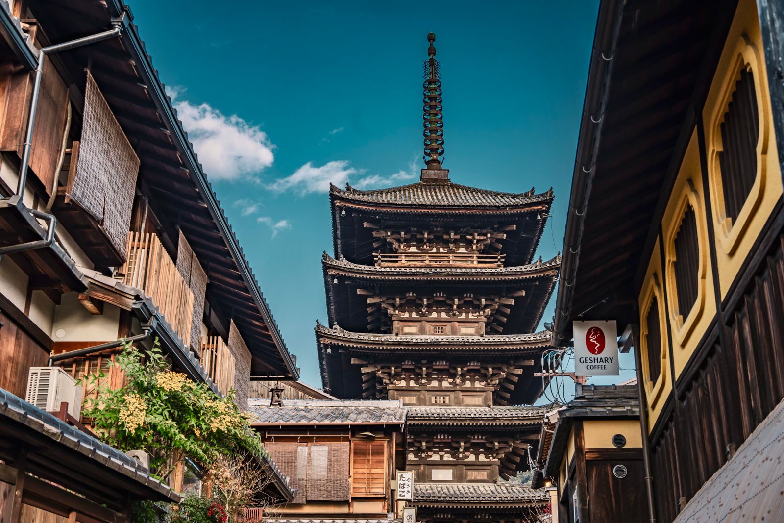 The five-story Yasaka Pagoda rising at the top of a narrow Kyoto lane lined with wooden machiya storefronts.