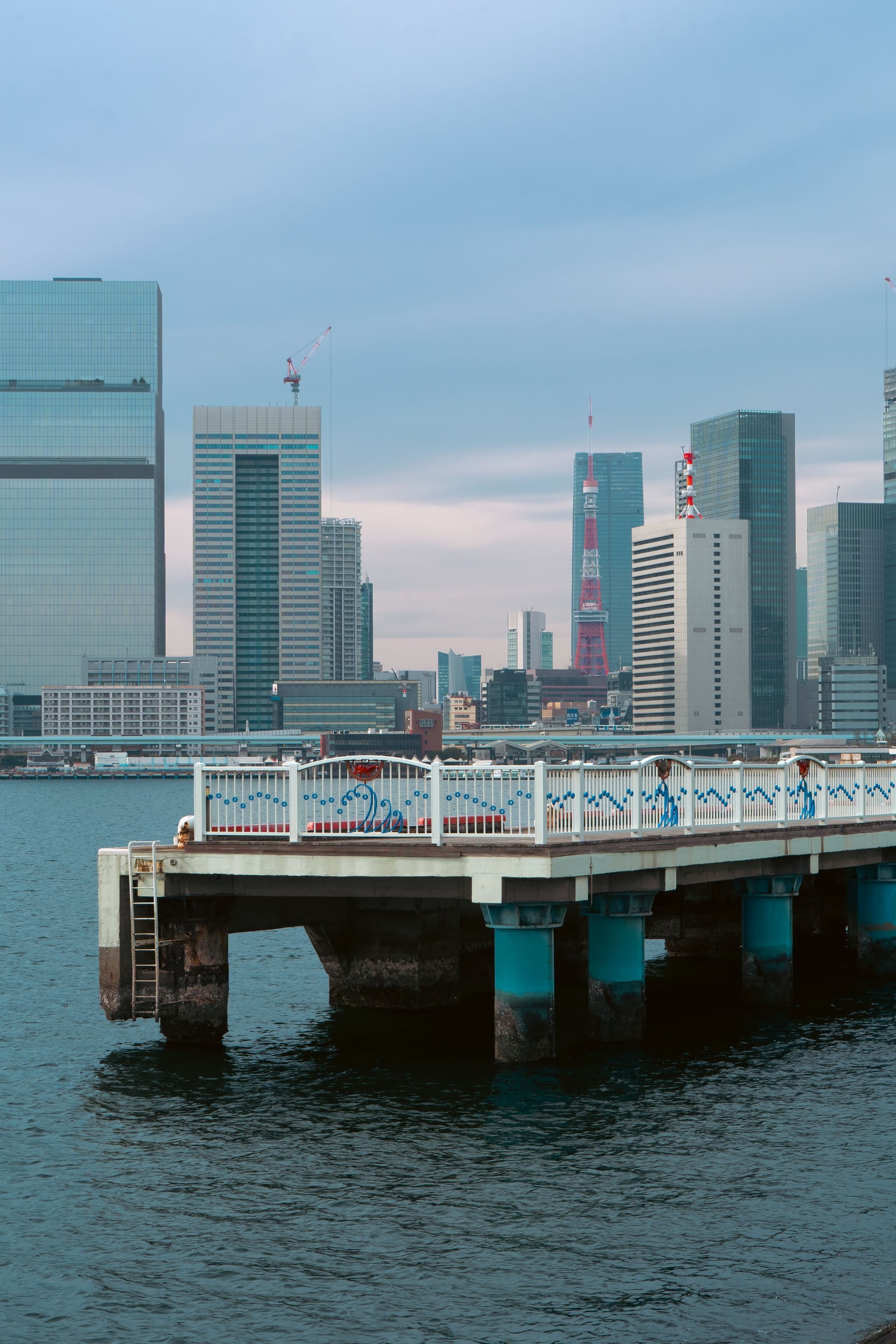A pier on Tokyo Bay with high-rise towers across the water.