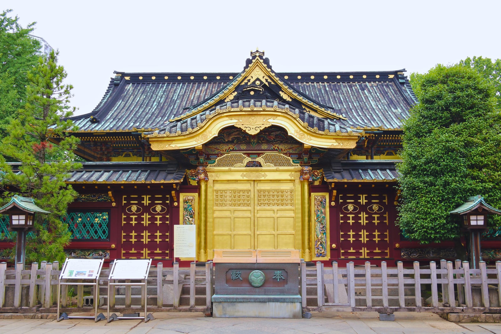 The front of Ueno Toshogu, a gold-leaf gateway in a red and gold wall under dark tiled roofs