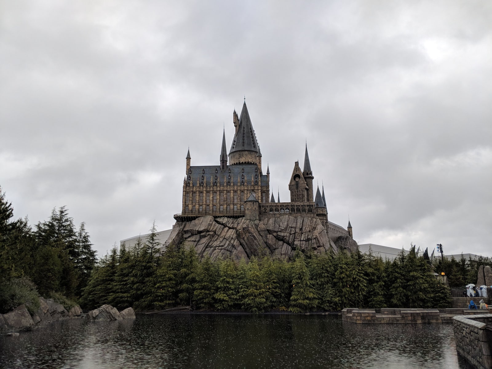 Hogwarts Castle seen across water under an overcast sky at the Wizarding World of Harry Potter.