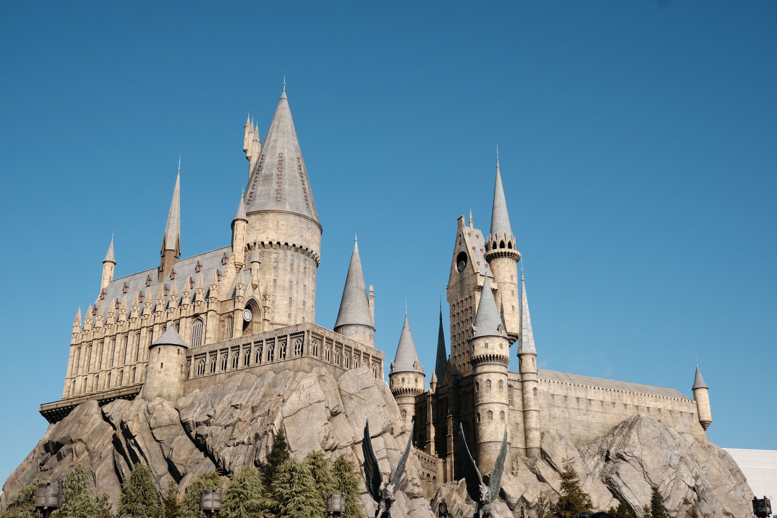 Hogwarts Castle viewed from below against a clear blue sky.