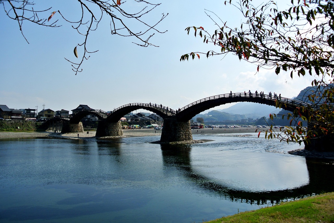 Kintaikyo, a wooden bridge of steep arches on stone piers, crossing the wide Nishiki River