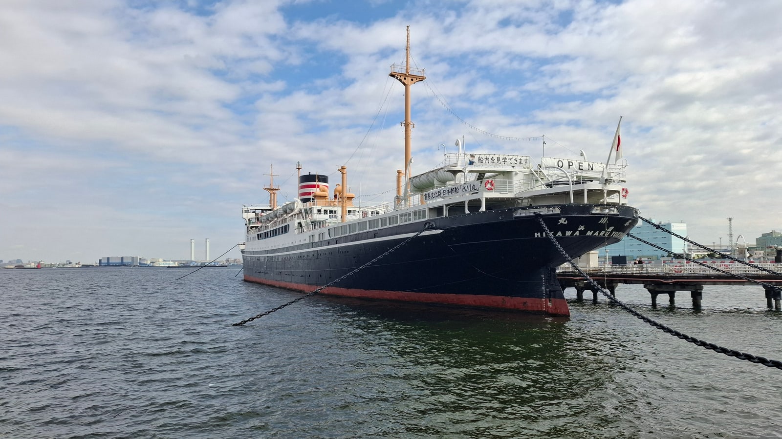 The black-hulled liner Hikawa Maru moored beside a pier under a cloudy sky
